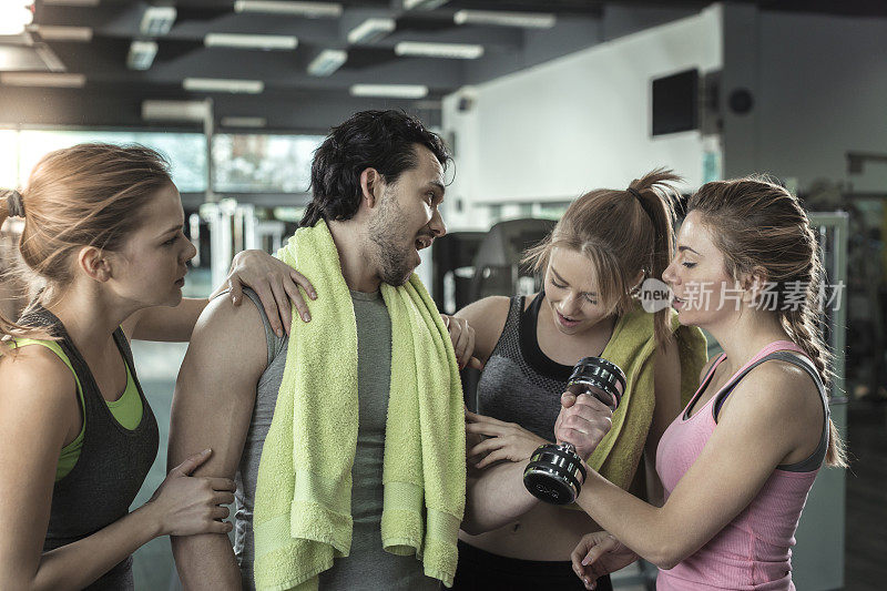 三个女人在健身房欣赏男人的肌肉