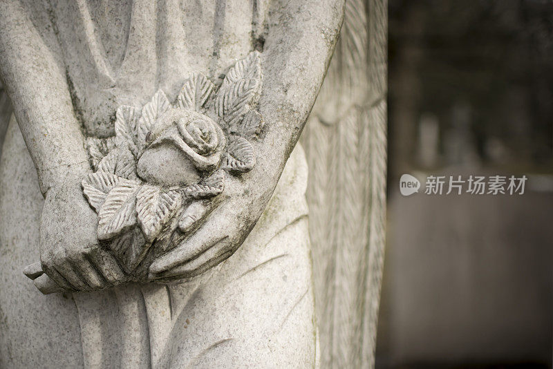 在墓地里有一个手持鲜花的天使雕像