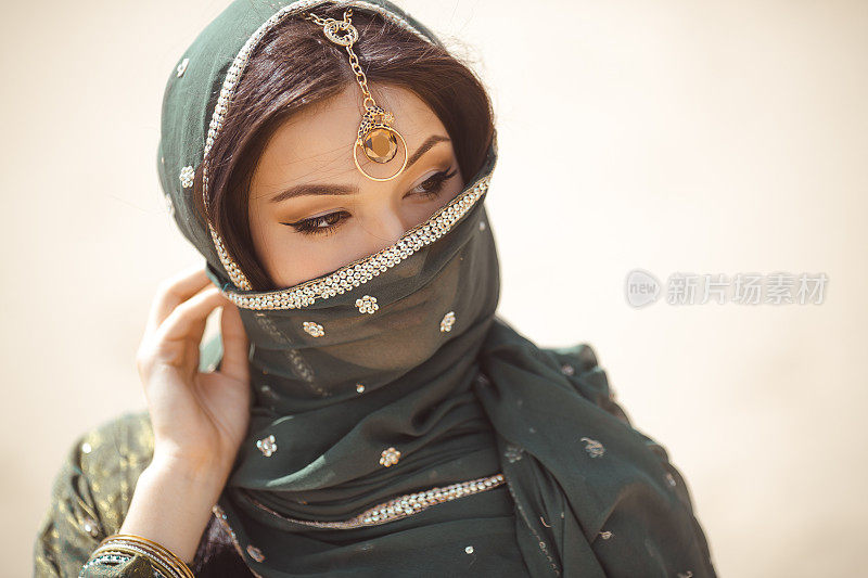 一个美丽的女性模特的肖像在传统民族服装与沉重的珠宝和化妆