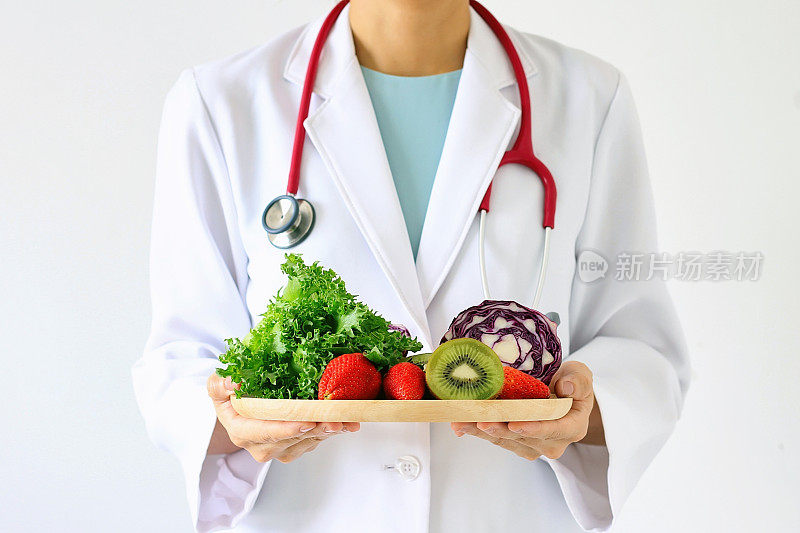 医生持新鲜水果和蔬菜，健康饮食，营养食品为良好的健康处方。
