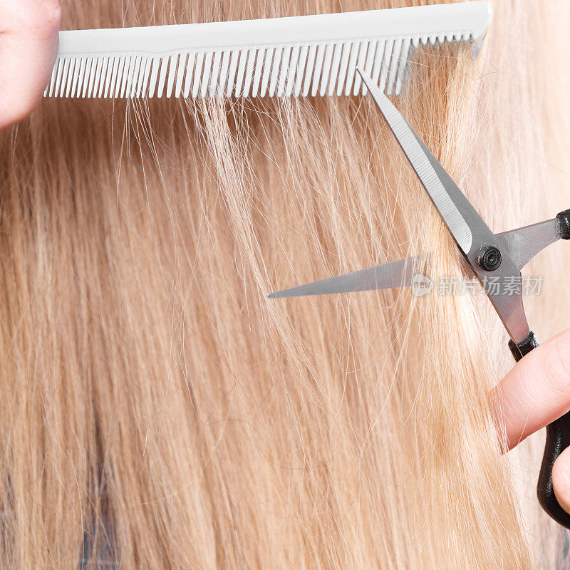 女人剪下光滑的头发。