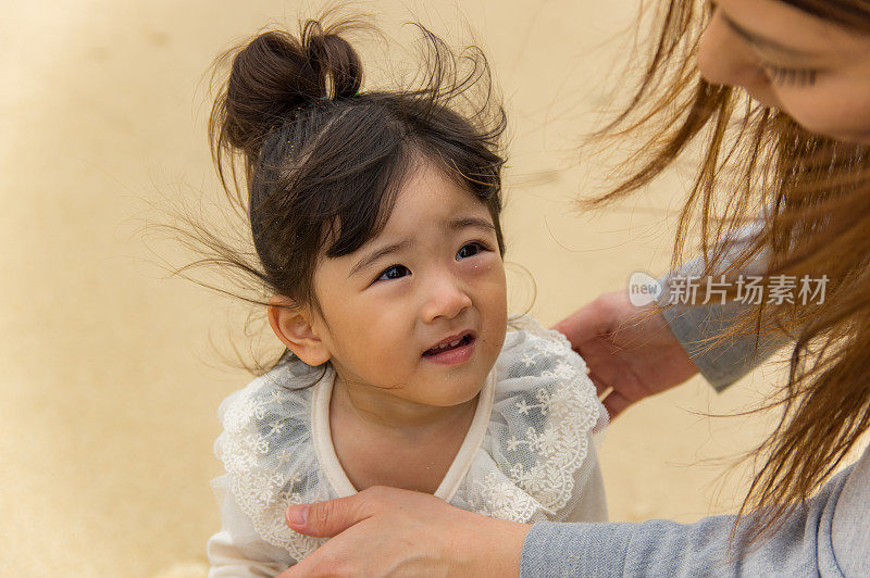 妈妈和小女孩在海滩上玩