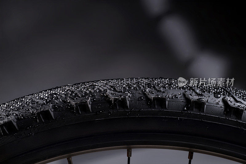 黑色自行车轮胎与水滴在抽象的背景。