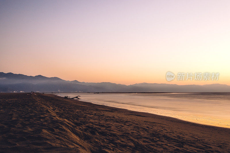 日落时分在美丽的海滩上散步