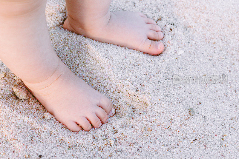 婴儿的脚在沙子里
