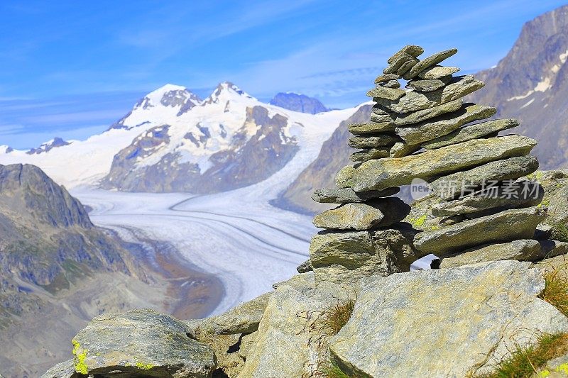 Inukshuk石头和极端地形景观:田园诗般的Aletsch冰川冰碛和冰裂缝山谷从Jungfrau山丘地平线上，戏剧性的瑞士雪山，田园诗般的乡村，伯尔尼斯高地，瑞士阿尔卑斯山，瑞士阿尔卑斯山
