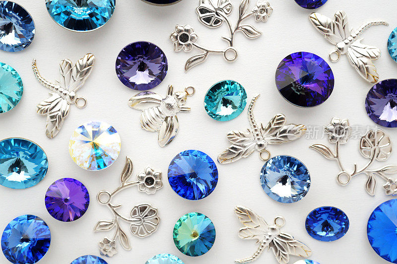 蓝色和紫色的水晶，金属蜜蜂，花朵和蜻蜓在白色的背景上