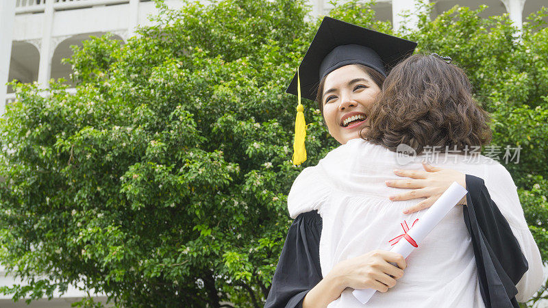 在祝贺仪式上，身着毕业礼服、头戴毕业帽的女同学拥抱家长。