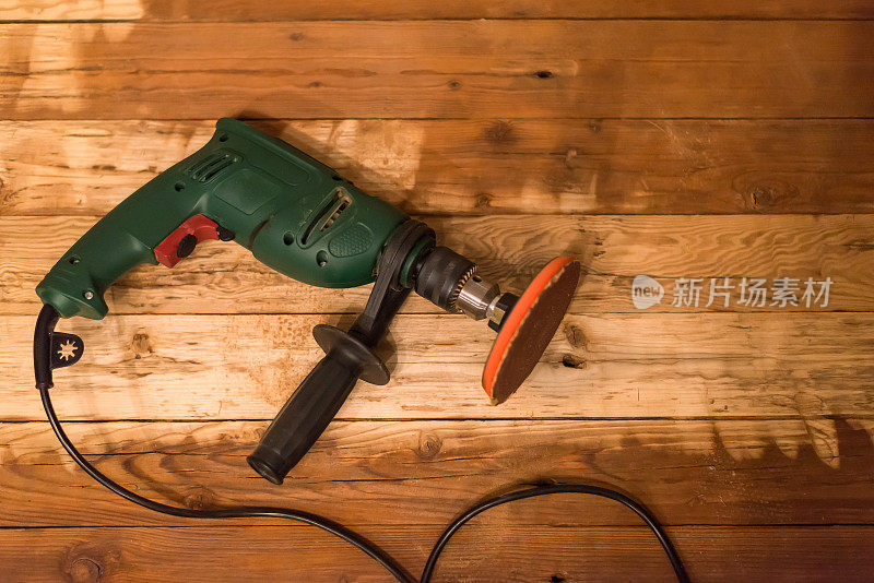 电动砂光机供家庭杂工使用，对木制背景。