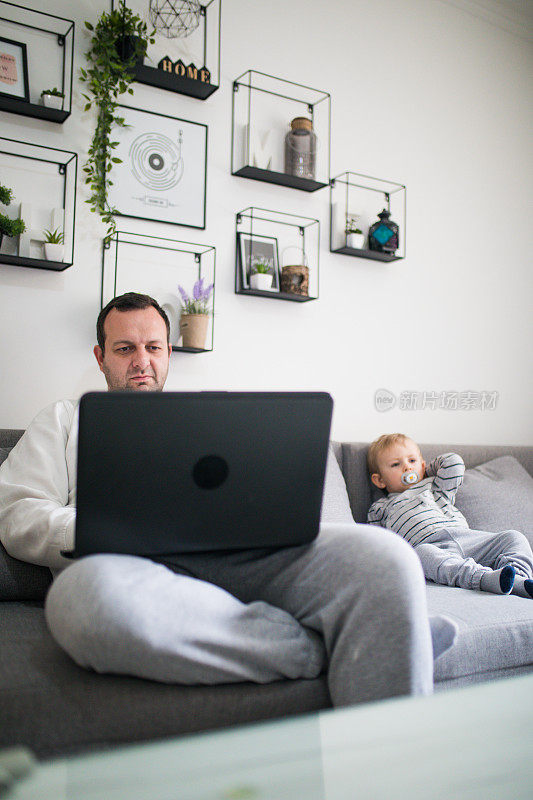 忙碌的爸爸和宝宝在电脑上工作