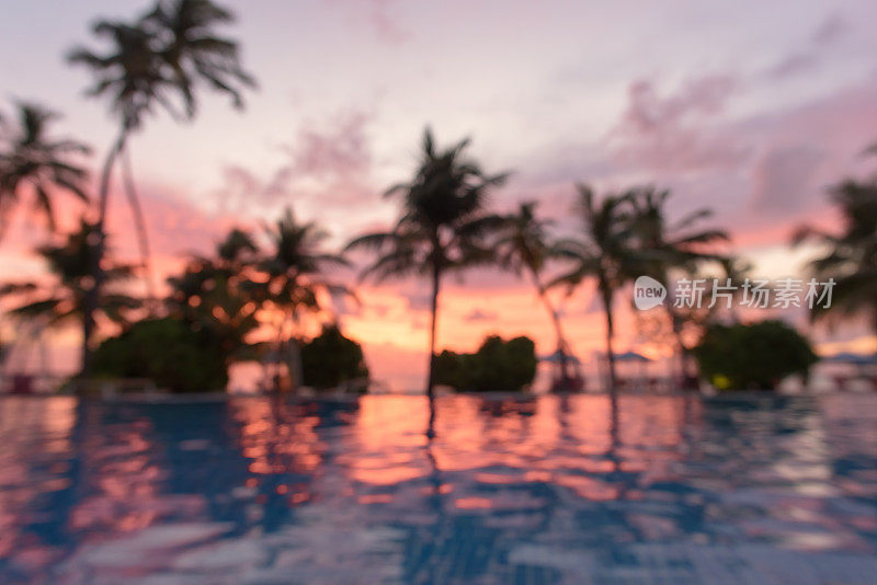 热带海滩游泳池和日落天空模糊抽象的背景