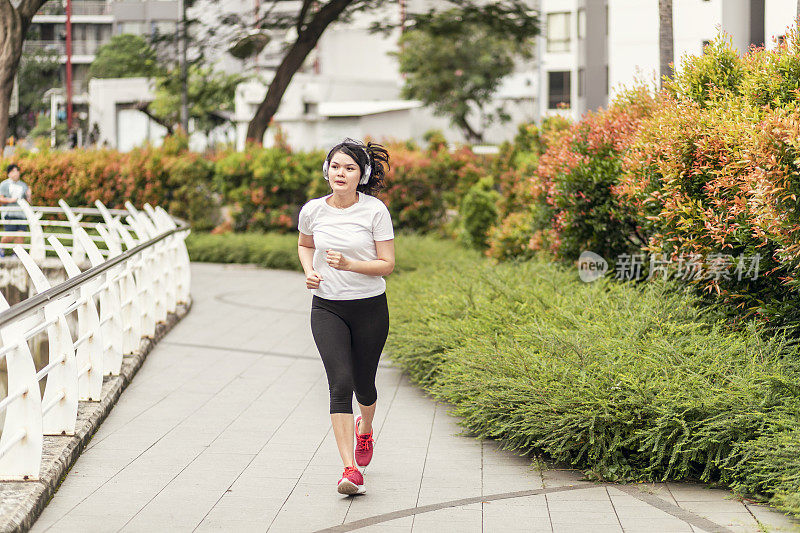 一个年轻女子在公园里跑步和锻炼