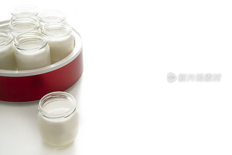 自制酸奶在酸奶制作机的玻璃罐上隔离白色的酸奶