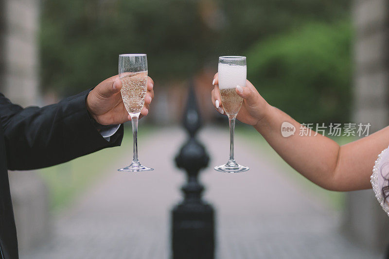 新娘和新郎举起香槟酒杯，祝新婚快乐