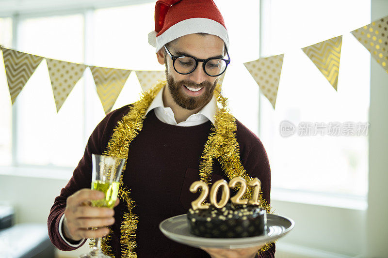 在新年派对上，戴着圣诞帽的人喝着香槟，拿着巧克力蛋糕