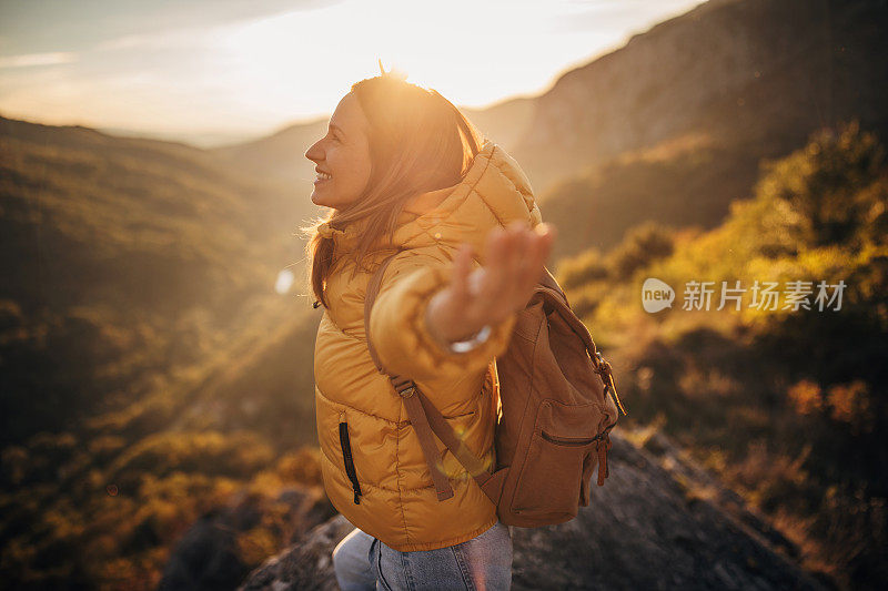 一位年轻美丽的徒步旅行者征服了山顶