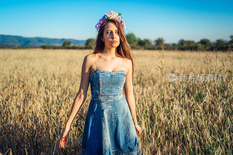 一个年轻女子正穿过一片麦田