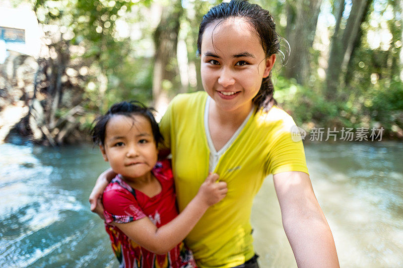 在河里，可爱的姐姐紧紧地抱着美丽的姐姐的表情