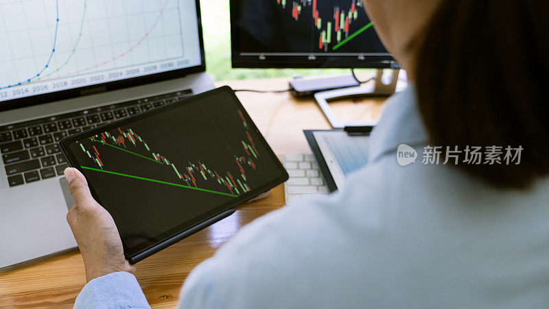 证券交易所交易员在现代化的交易办公室里，在显示器上处理图表。