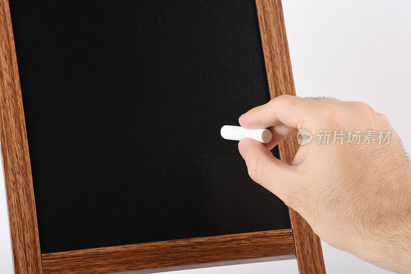 男人的手拿着粉笔与空干净的黑板在白色的背景