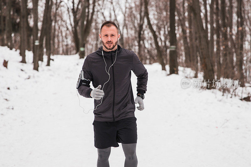 健康人在雪地上慢跑，一边慢跑一边听音乐