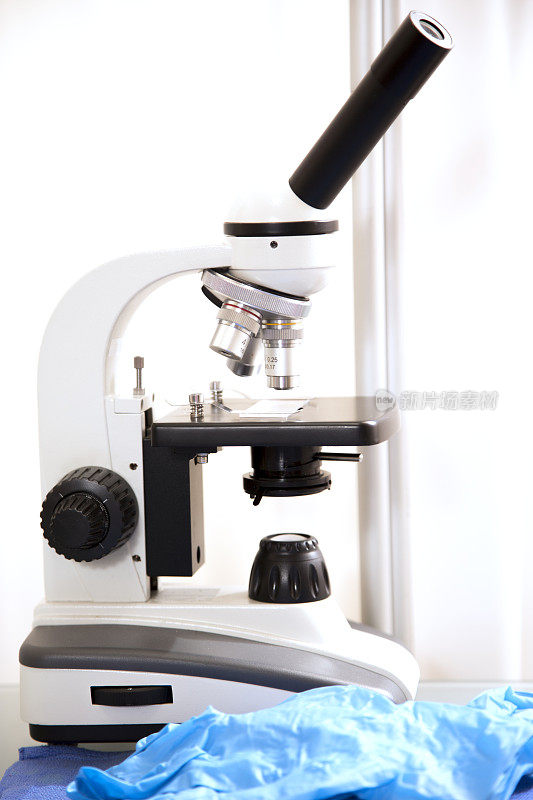 医疗-解剖或手术工具。背景显微镜，前景手术工具。
