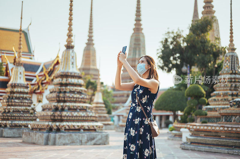 广角拍摄千禧一代和Z世代微笑泰国亚洲外科口罩在曼谷的中国寺庙拍照