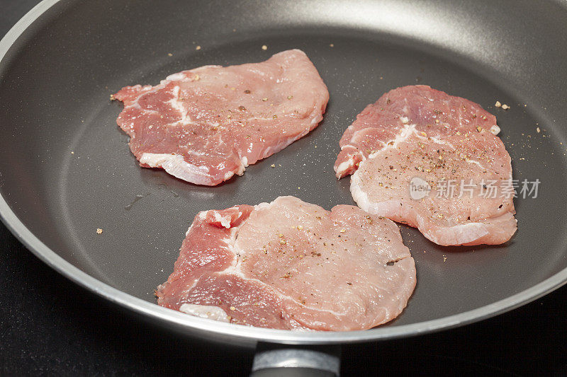 煎锅里的猪肉和胡椒粉…饮食时间……没有石油