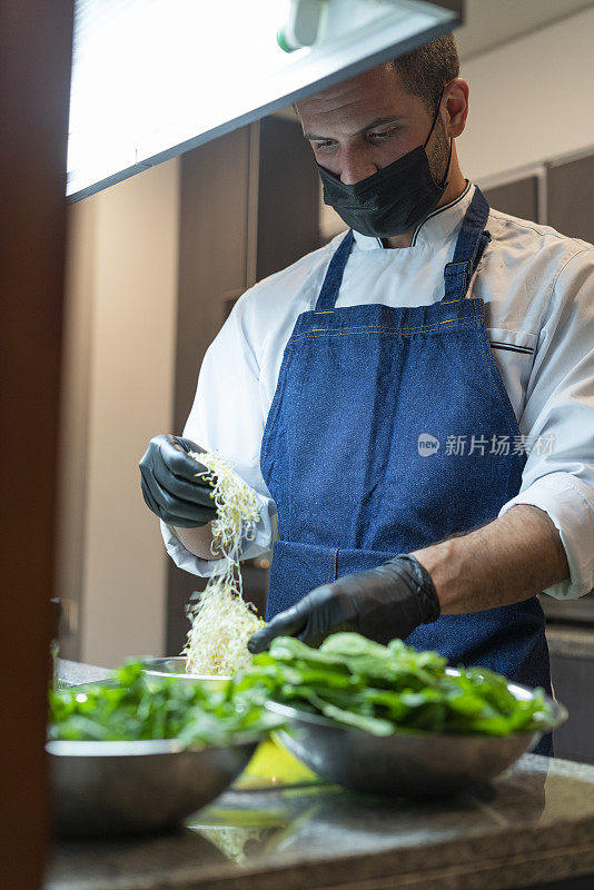 拉丁职业厨师被雇佣在他的客人的家里准备美味的菜肴在疫情期间