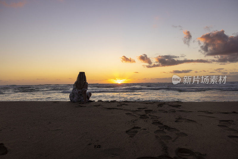 意大利撒丁岛，夕阳西下的海滩上抑郁的女人。