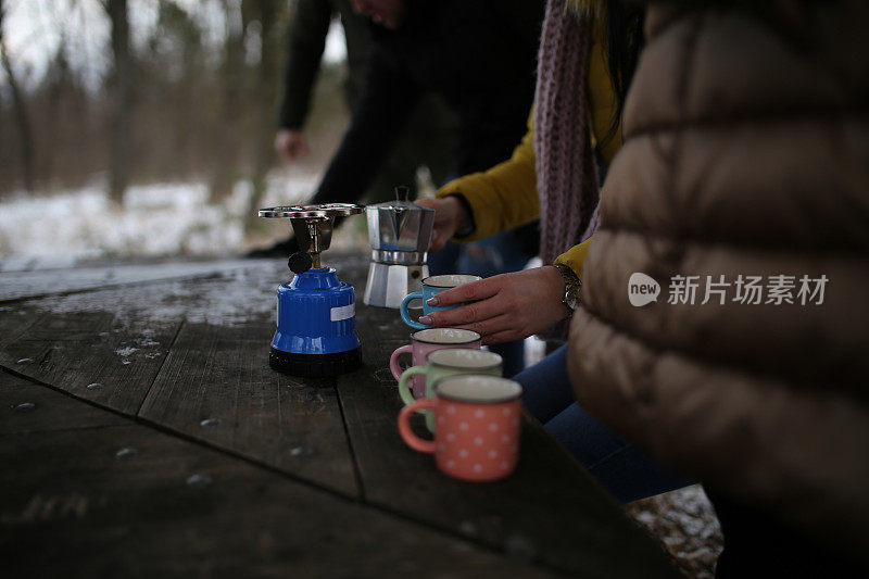 朋友们在雪堆上喝着热饮的照片