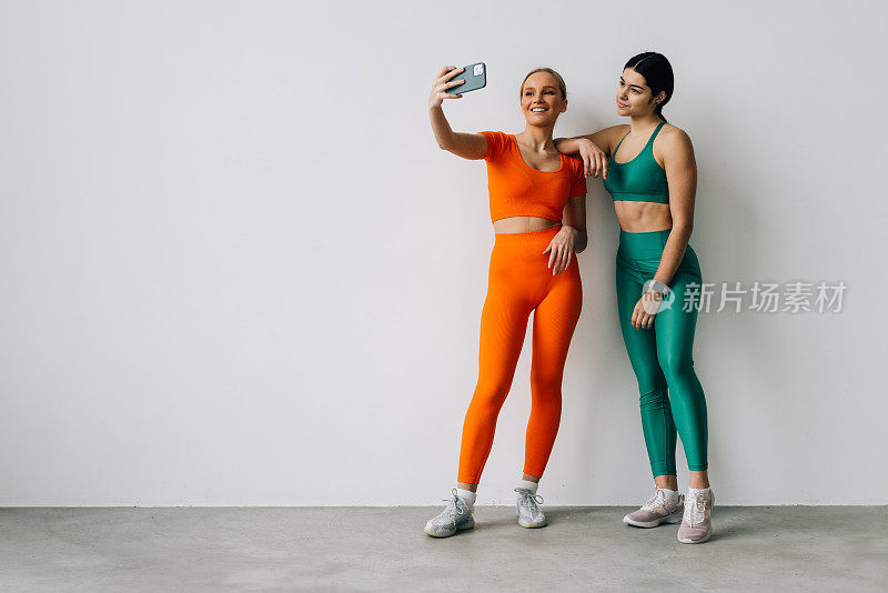 两个年轻女人在健身房一起自拍