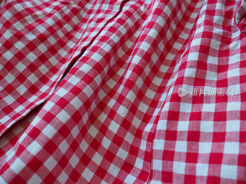 红色和白色的格子背景与条纹广场野餐毯，台布，格子，衬衫和纺织品。面料质地。红白两色方框棉布，皱折成波浪状。