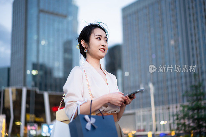 亚洲商业女性站在城市街头，写字楼背景，成功、自信的女性理念