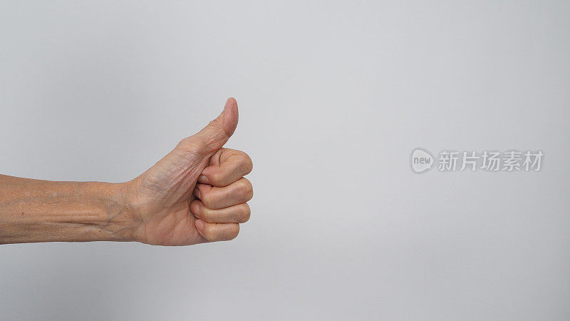年长或年长女性的手在白色背景上做大拇指。