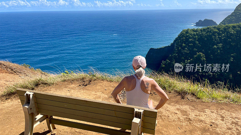 老妇人坐在长凳上俯瞰夏威夷波洛卢山谷