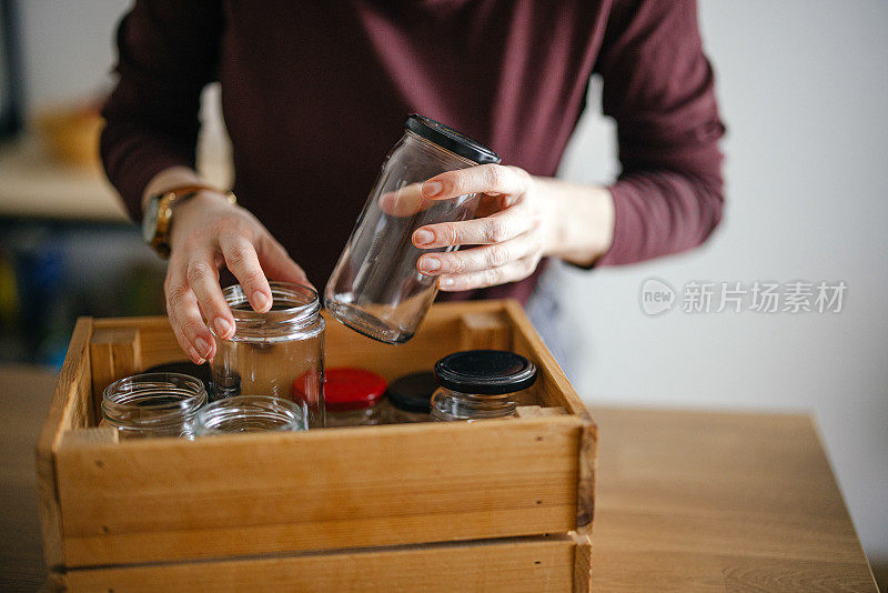 一位匿名妇女在家回收玻璃废料