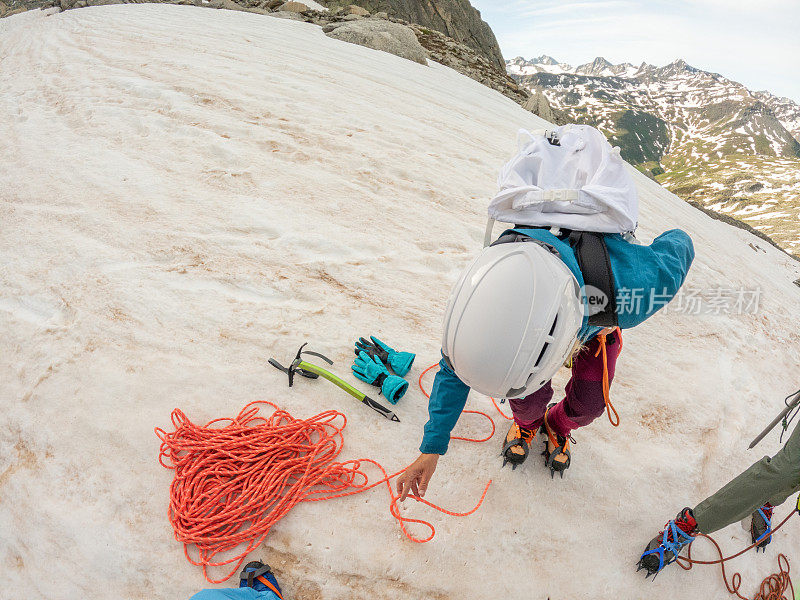 为攀登冰川准备装备的女登山者