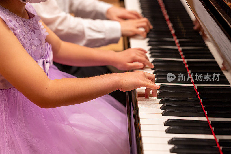 小女孩和她的老师一起弹钢琴
