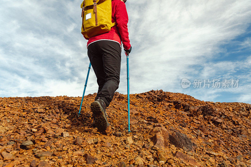 一位女性徒步旅行者走向山峰