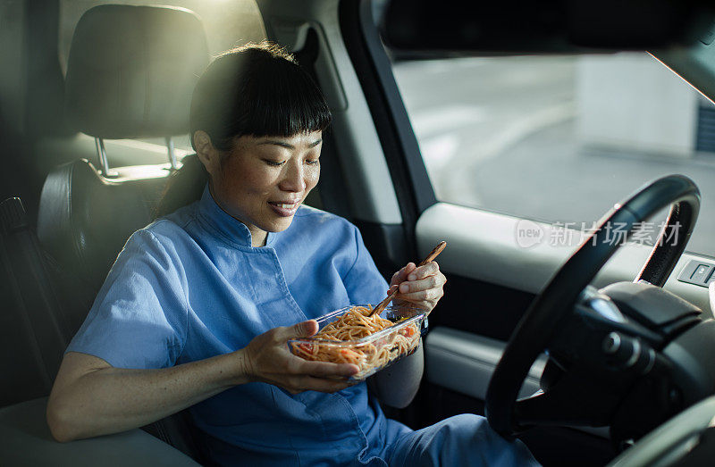 年轻的日本医护人员在车里吃午饭