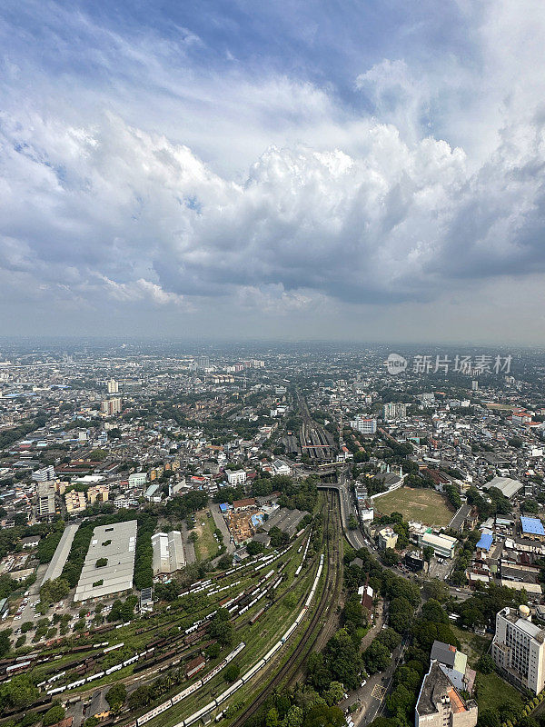 斯里兰卡科伦坡的城市景观图片，首都的摩天大楼，港口，道路，铁路轨道，港口起重机，蓝色多云的天空，重点在前景