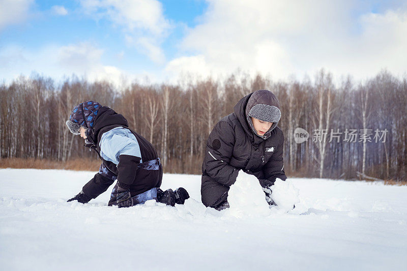 孩子们穿着暖和的衣服在阳光明媚的冬日里玩雪，打雪仗，玩得很开心。休闲活动，节日快乐。