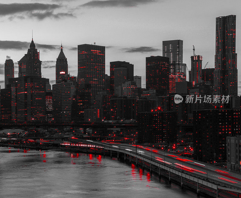 红色的灯光映照在黑白相间的城市景观中，夜晚的纽约曼哈顿市中心的天际线建筑