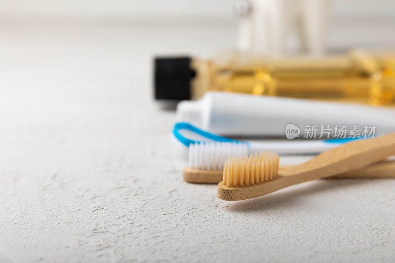 口腔卫生用品和牙齿模型在一个白色的木制背景。白色背景上的牙刷、牙膏和漱口水。牙科保健概念。口腔卫生。口腔护理理念。本空间