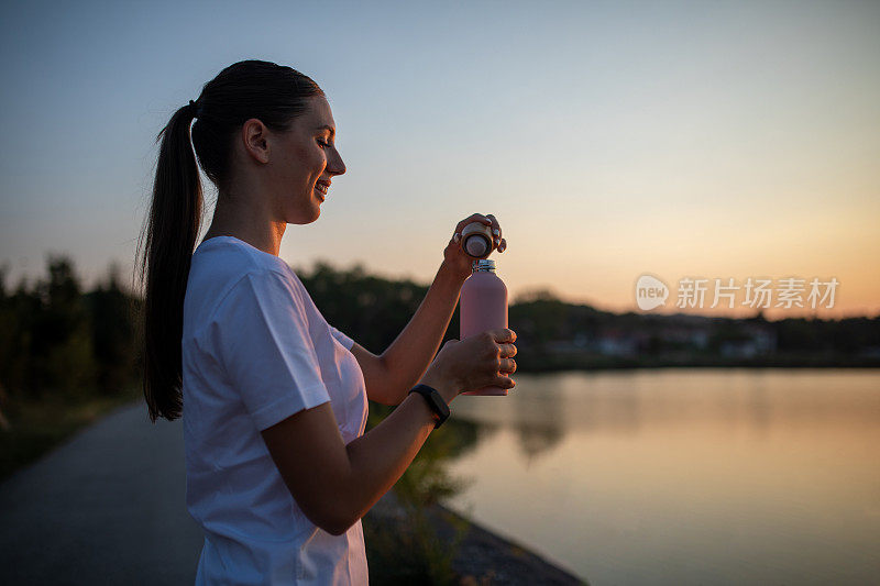 年轻漂亮的女子在河边饮水后奔跑