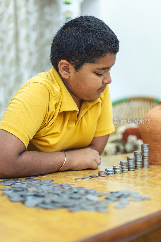 一幅印度小孩把硬币放进硬币堆的肖像