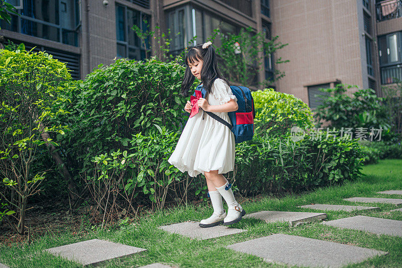 女孩放学后高高兴兴地回家，一个女孩背着背包