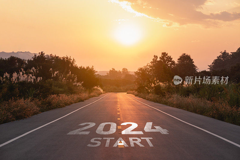 2024年新年快乐，2024年象征着新的一年的开始。信中开启了新的2024年道路上的自然路线道路上的夕阳树环境生态或绿色壁纸的概念。