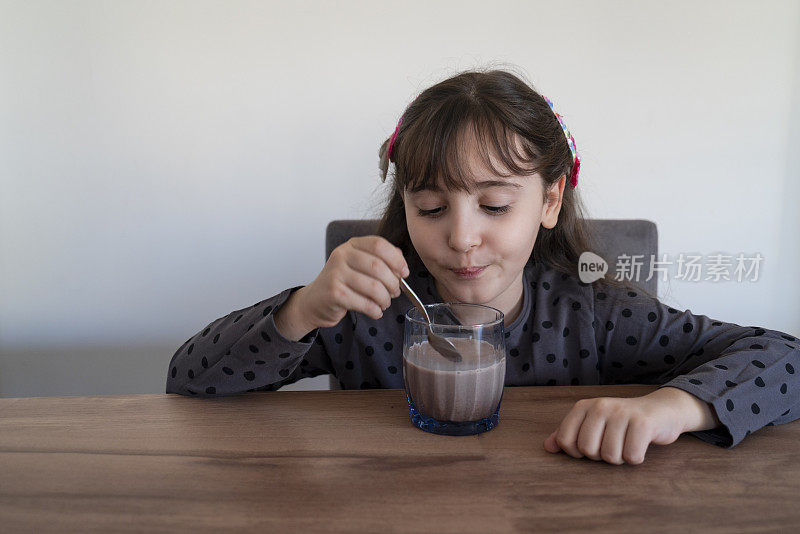 小女孩正在准备一杯巧克力牛奶